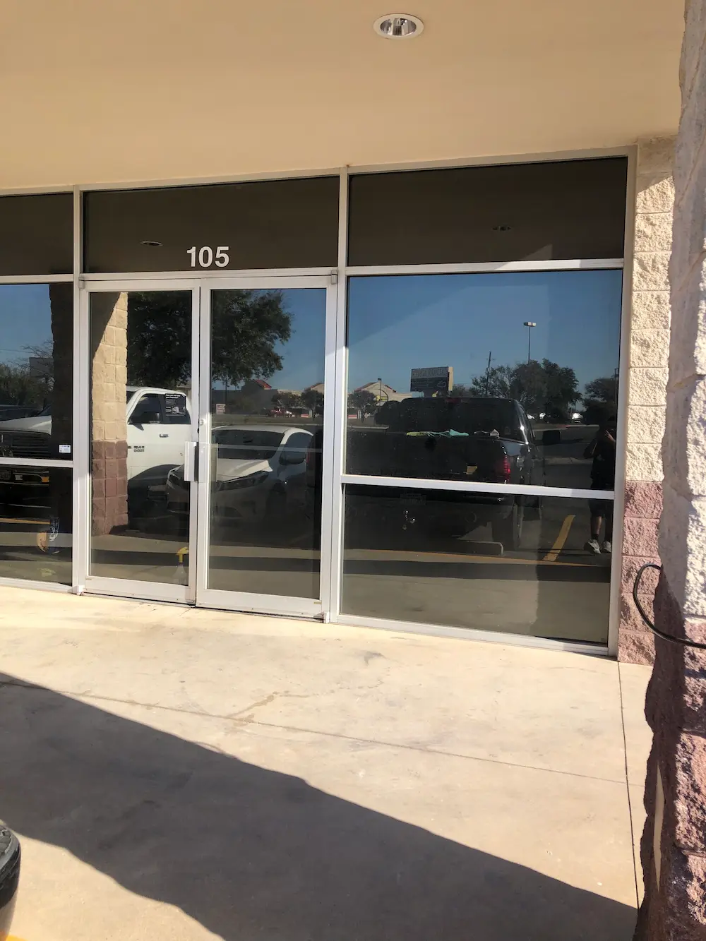 Commercial storefront with dark tinted windows and glass doors in Pflugerville